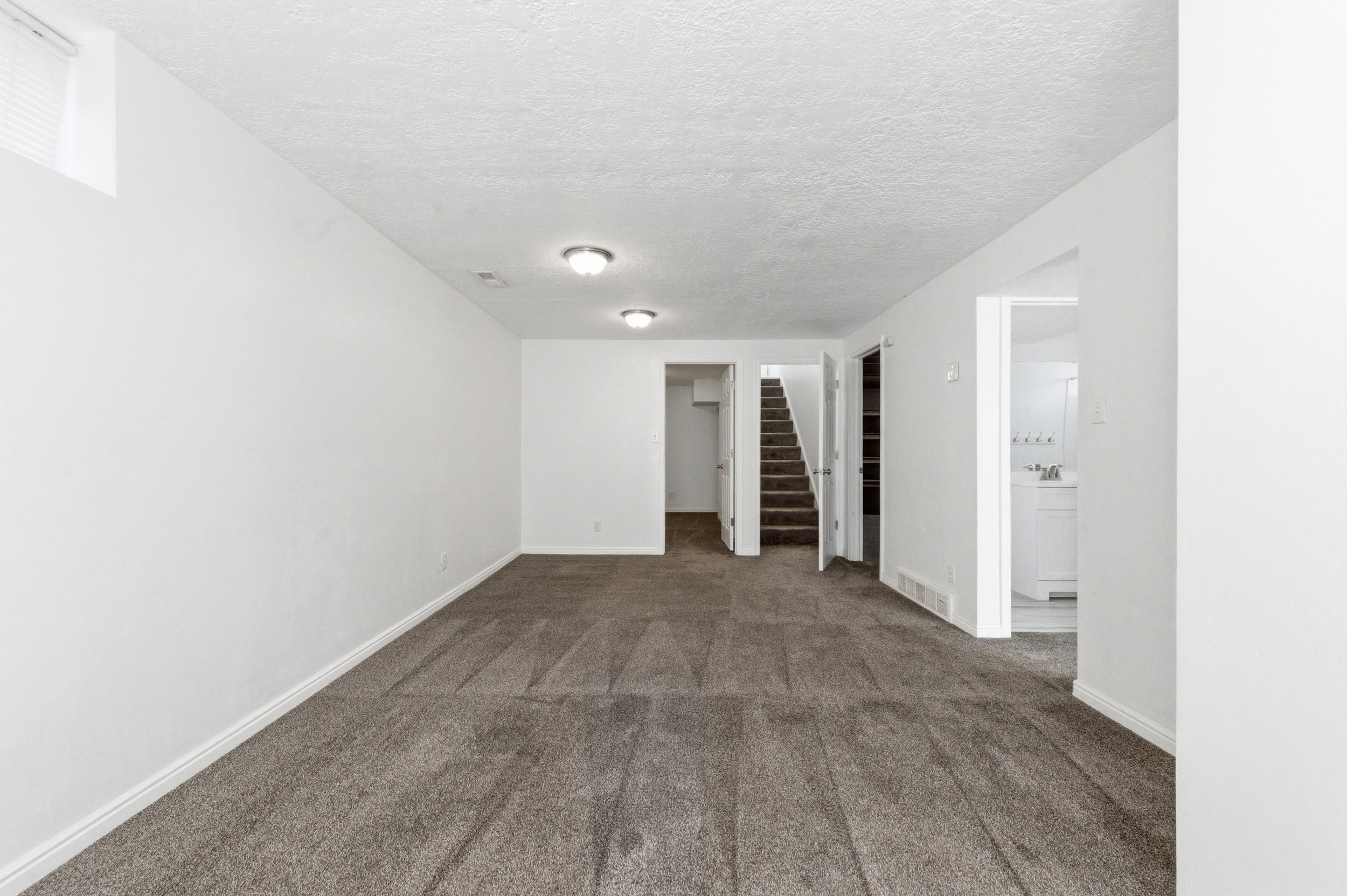 Unfurnished room with a textured ceiling and dark carpet