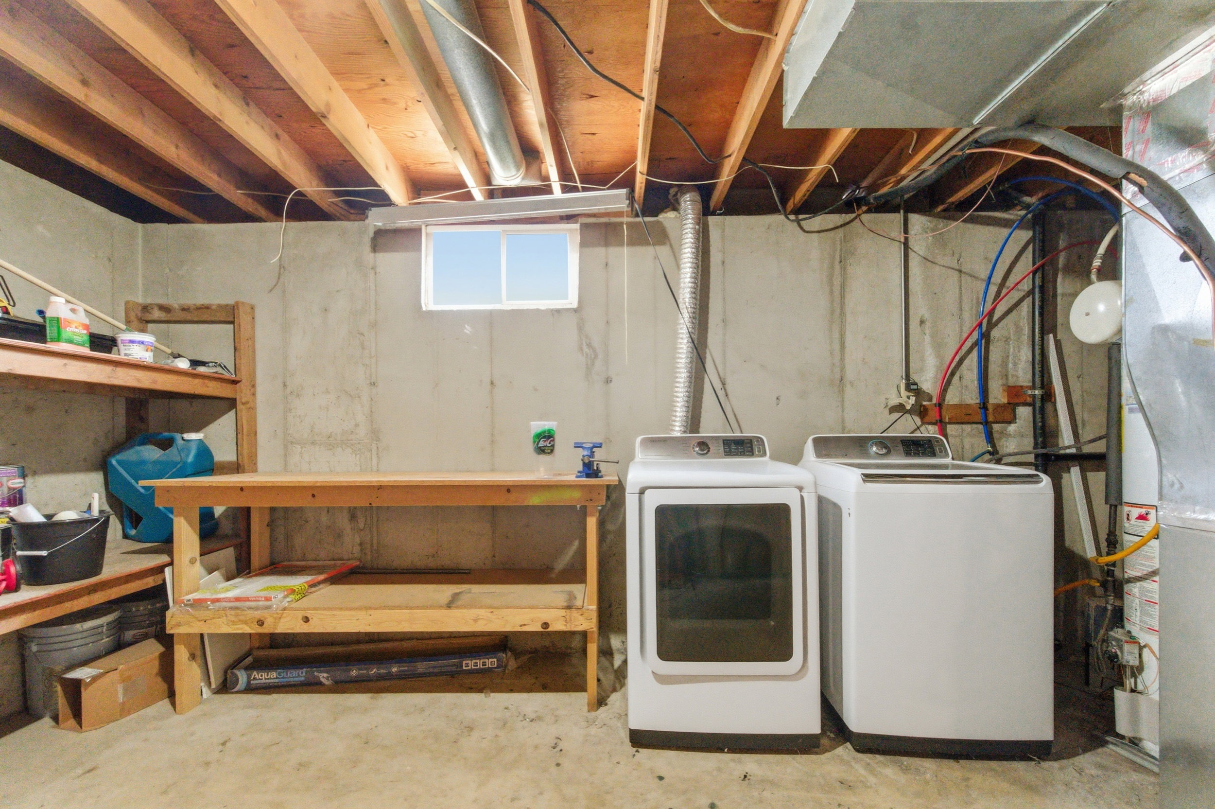 Laundry area featuring concrete floors and washing machine and clothes dryer