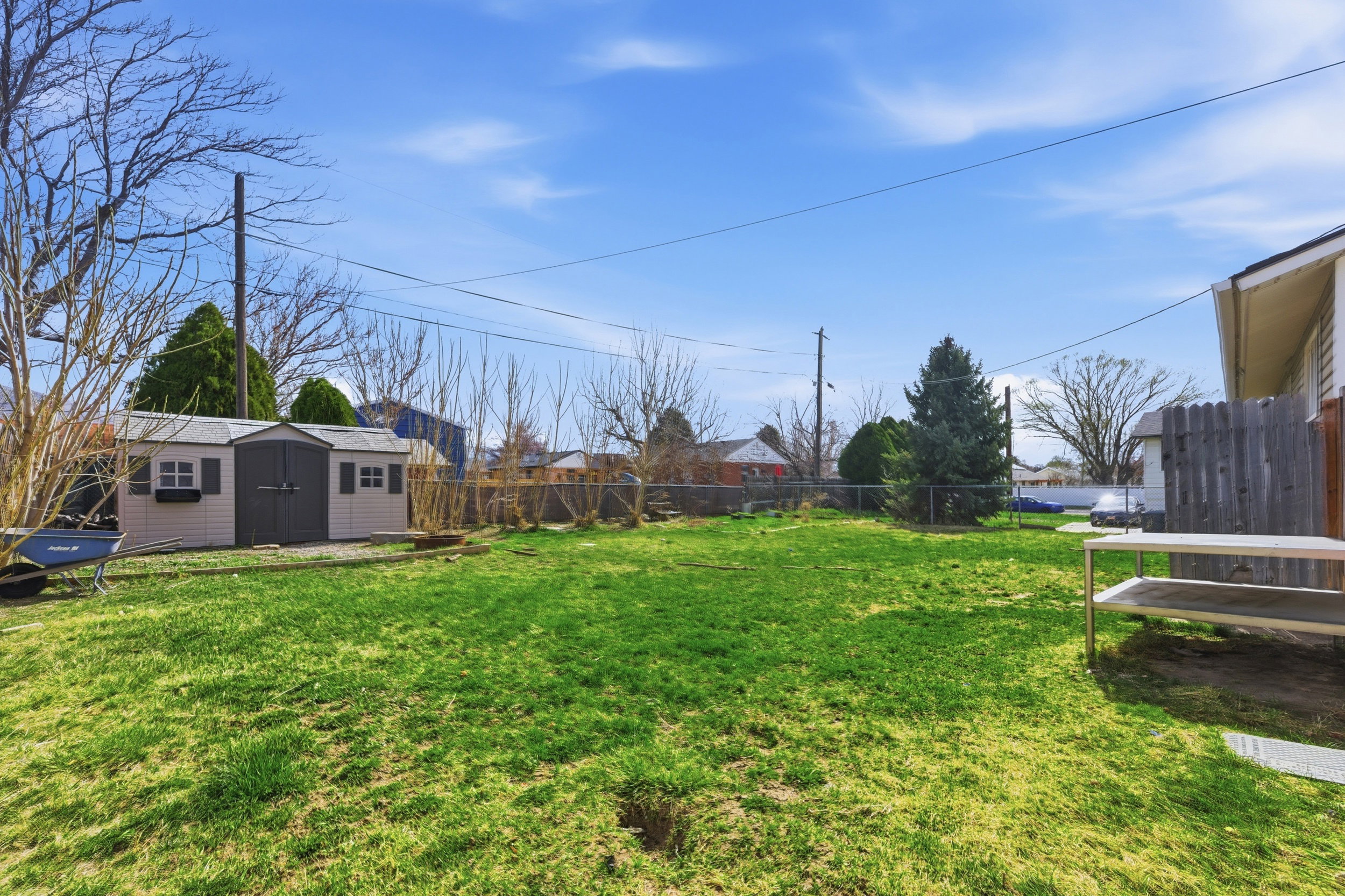 Fenced backyard with an outbuilding