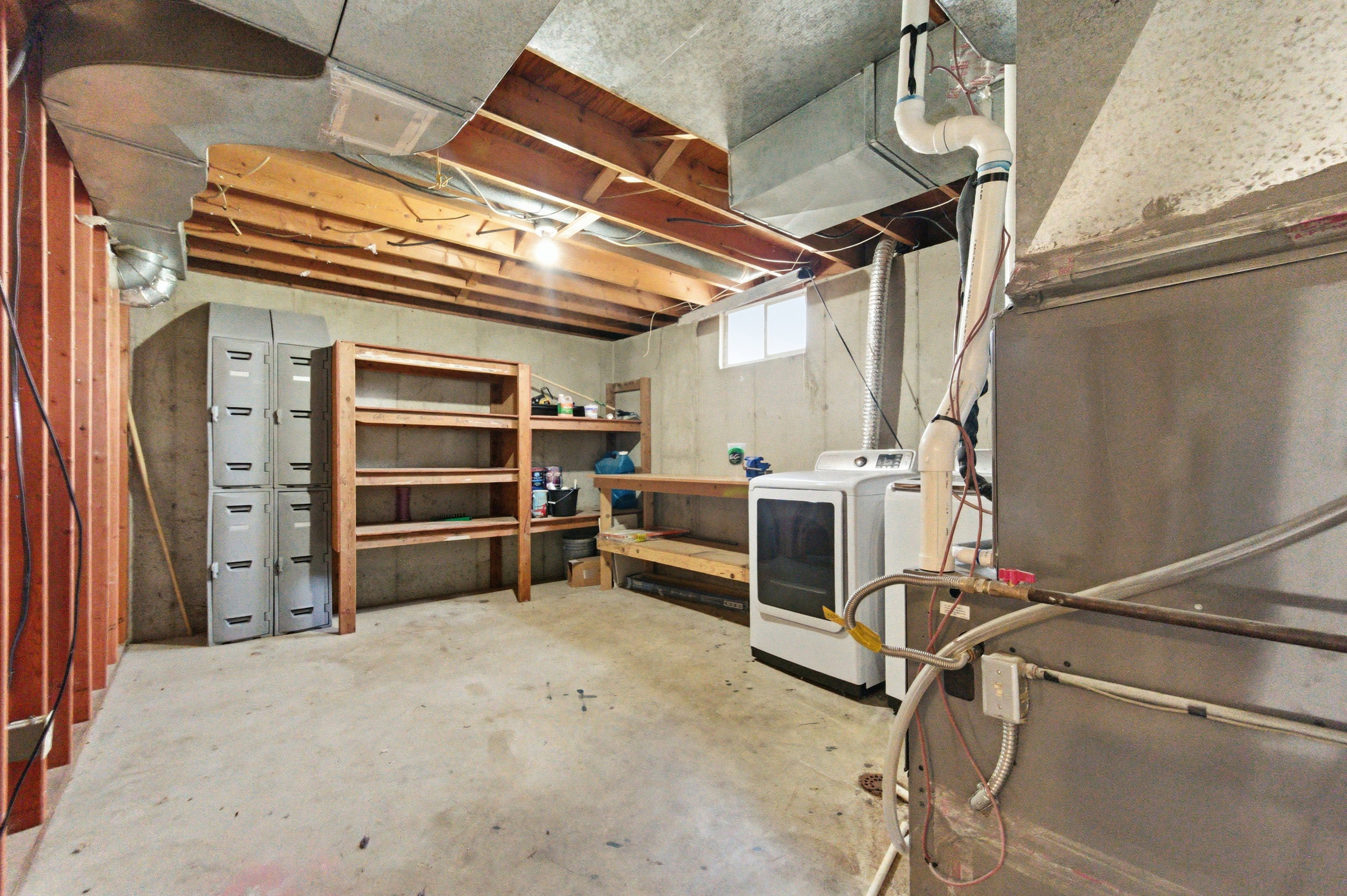 Basement featuring heating unit and washer / clothes dryer