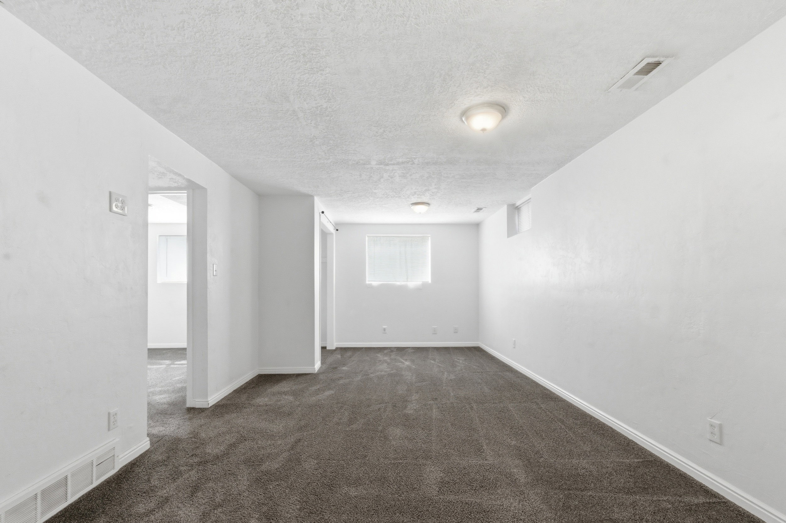 Spare room featuring dark colored carpet and a textured ceiling