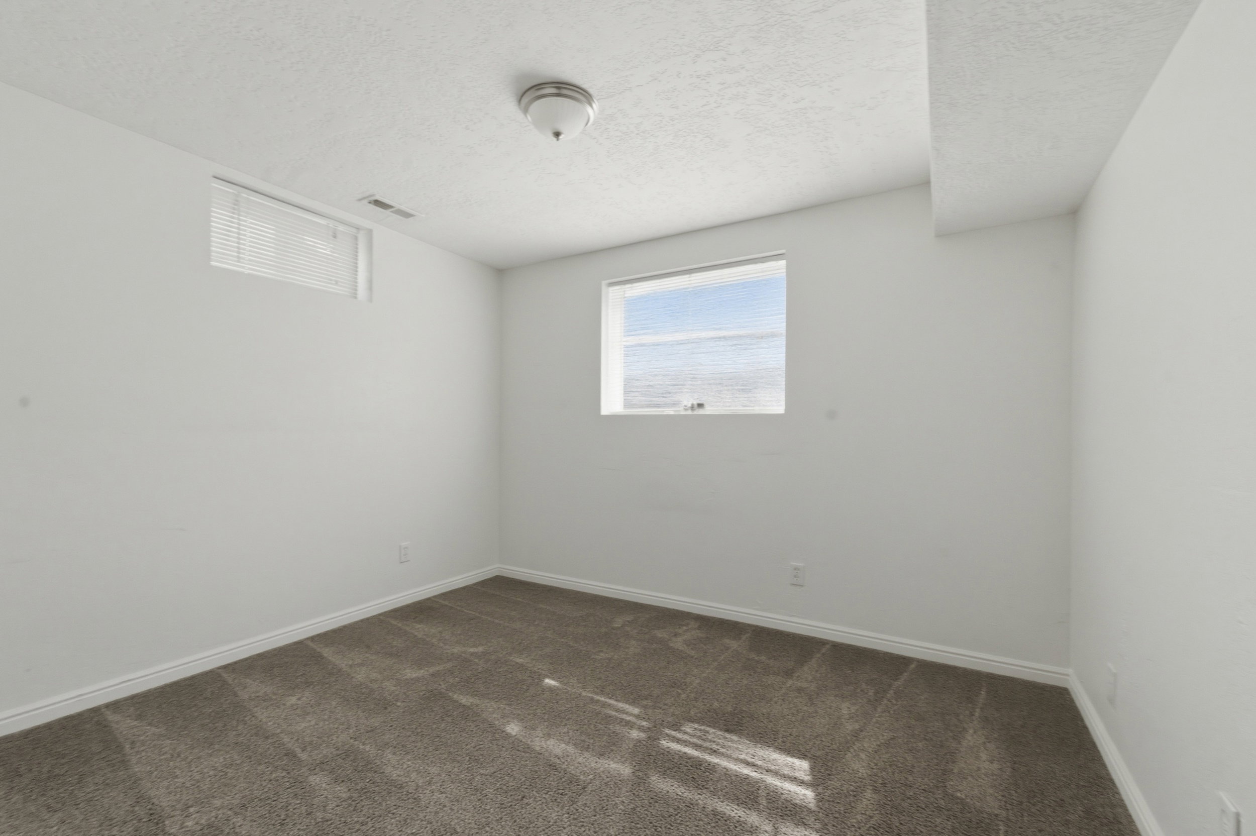 Empty room with dark colored carpet and a textured ceiling