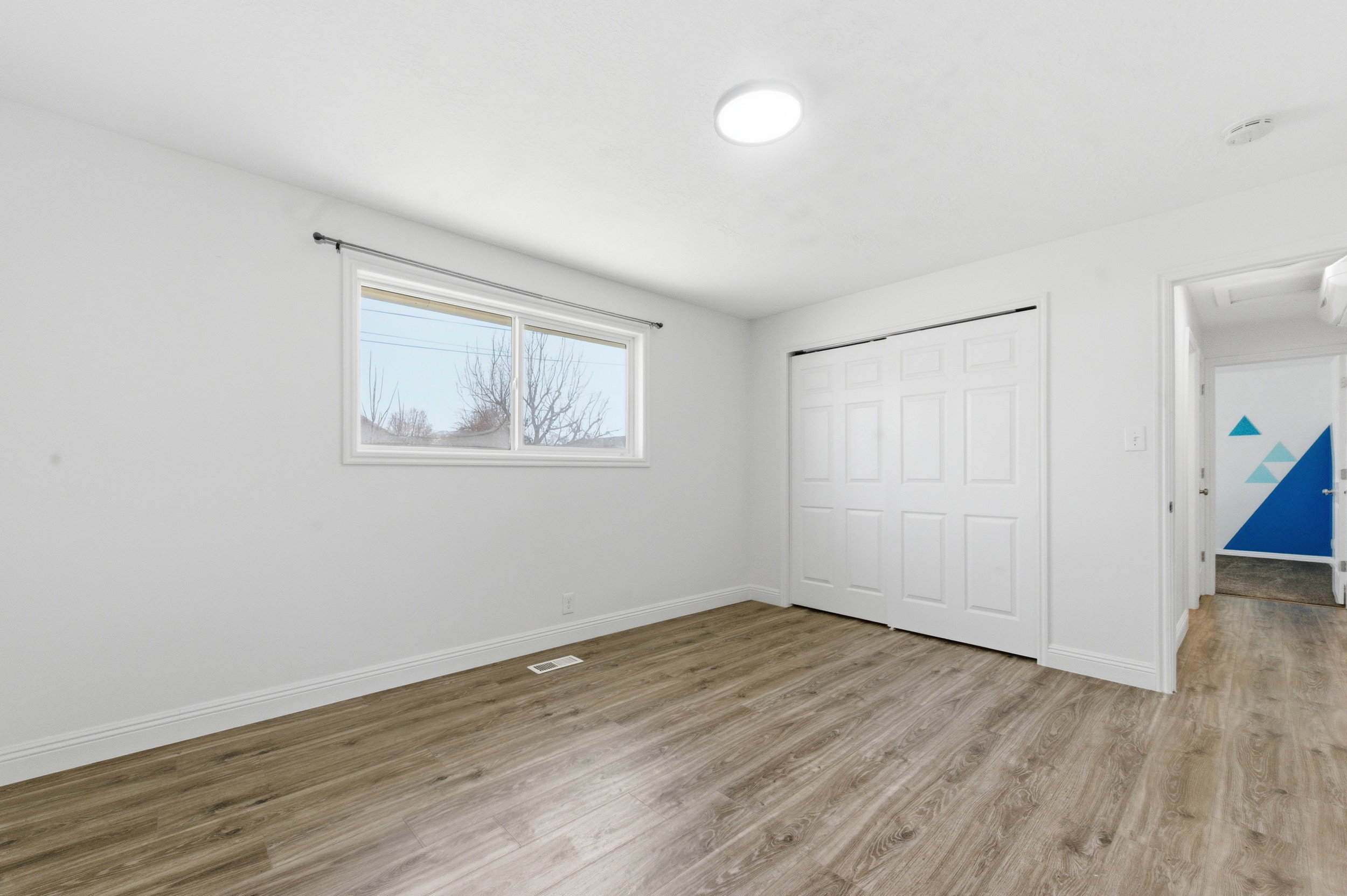 Unfurnished bedroom featuring light wood-style floors and a closet