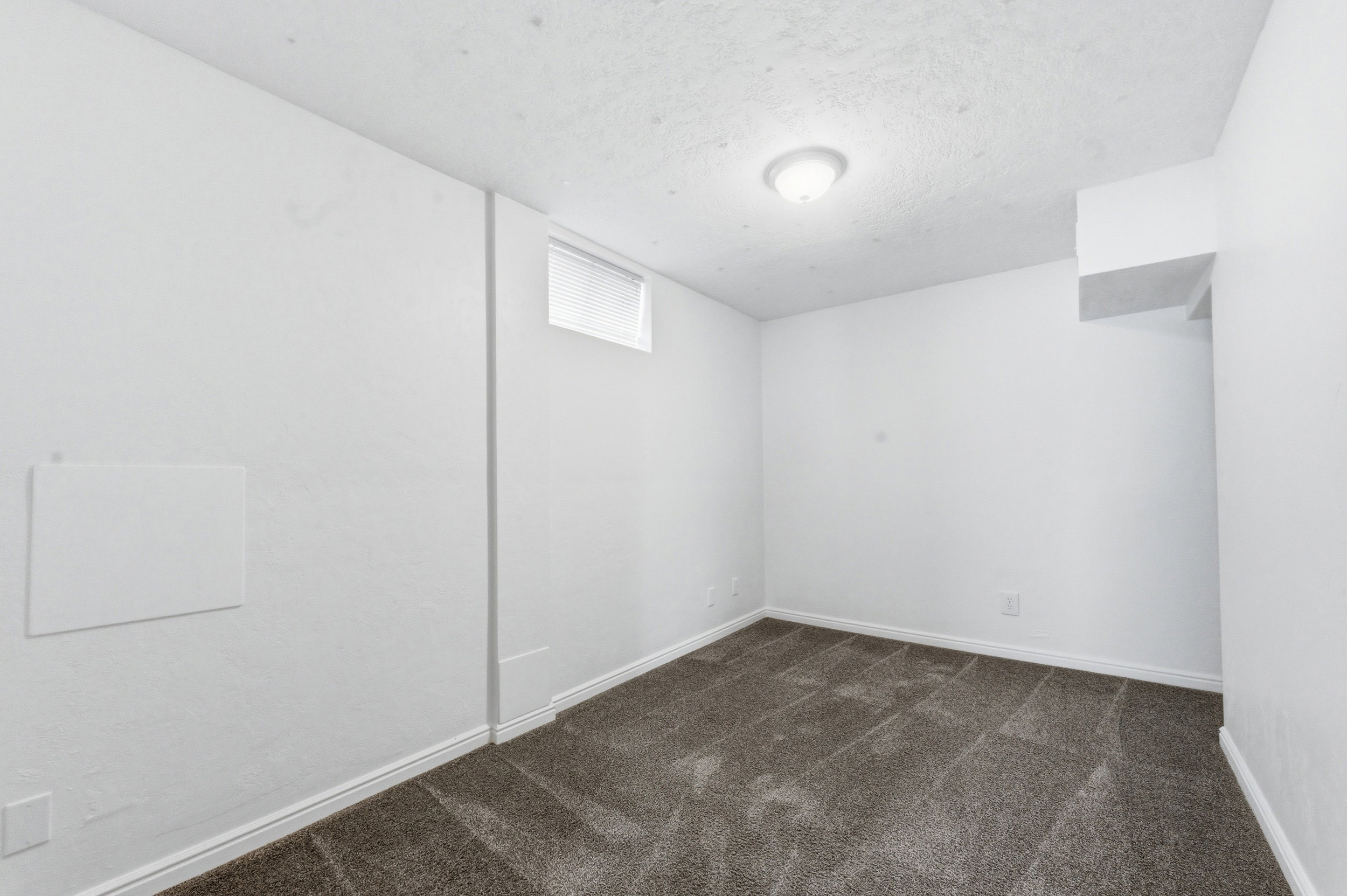 Spare room with dark colored carpet and a textured ceiling