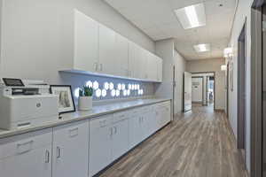 Kitchen with light countertops, white cabinetry, and a drop ceiling