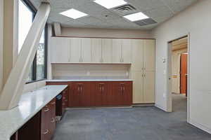 Kitchen featuring a drop ceiling and dark carpet