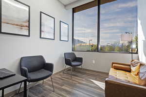 Sitting room with dark wood-type flooring and baseboards
