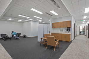 Interior space featuring light countertops, a high drop ceiling, wood finish cabinets, and open floor plan