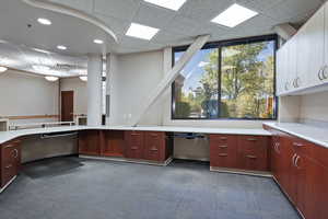 Kitchen featuring built in desk, light countertops, and a drop ceiling