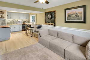 Living room featuring a ceiling fan, light wood-style floors, and beverage cooler