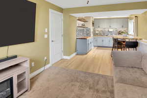 Living room with light wood finished floors and light colored carpet