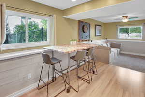 Dining area with ceiling fan and light wood-style floors