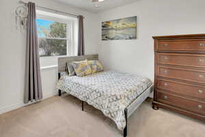 Bedroom featuring light colored carpet and baseboards