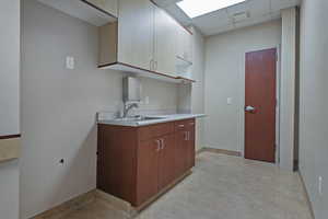 Kitchen with a drop ceiling and light countertops