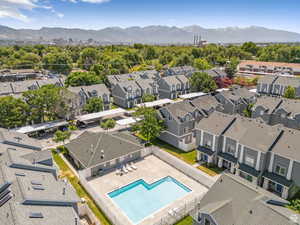 Aerial perspective of suburban area with a mountain backdrop and a pool