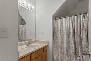 Bathroom with a shower with curtain and vanity