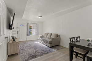Living area featuring light wood-style floors and baseboards