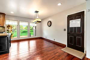 Unfurnished dining area featuring dark wood-type flooring and recessed lighting