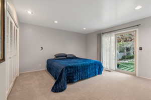 Bedroom featuring light colored carpet, recessed lighting, and access to outside