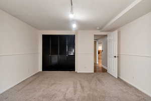 Unfurnished bedroom with light colored carpet and a closet