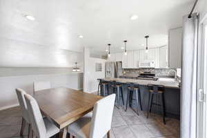 Dining room with light tile patterned flooring and recessed lighting
