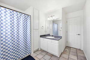 Bathroom with vanity, a shower with shower curtain, and light tile patterned floors