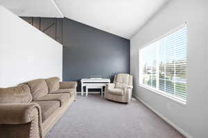 Living area featuring vaulted ceiling and carpet flooring