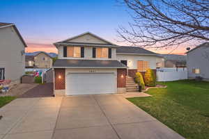 Tri-level home with brick siding, driveway, and a garage