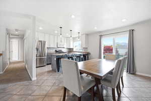 Dining area with light tile patterned floors and recessed lighting