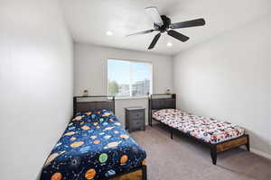 Carpeted bedroom featuring ceiling fan