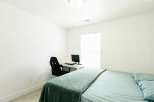 Bedroom with an office area and carpet flooring