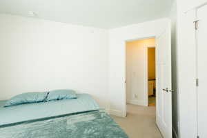 Bedroom featuring light colored carpet and baseboards
