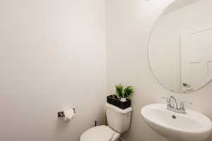 Half bath featuring toilet and a sink