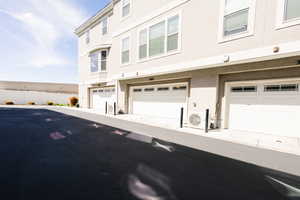 Exterior space with stucco siding and an attached garage