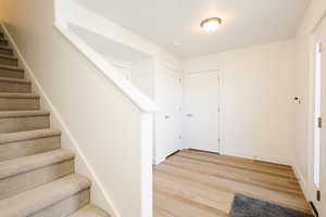 Entrance foyer with stairway and light wood-style floors