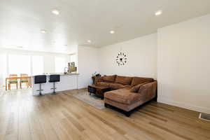 Living room with light wood finished floors and recessed lighting