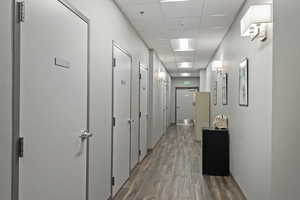 Hall featuring a drop ceiling and dark wood-style flooring