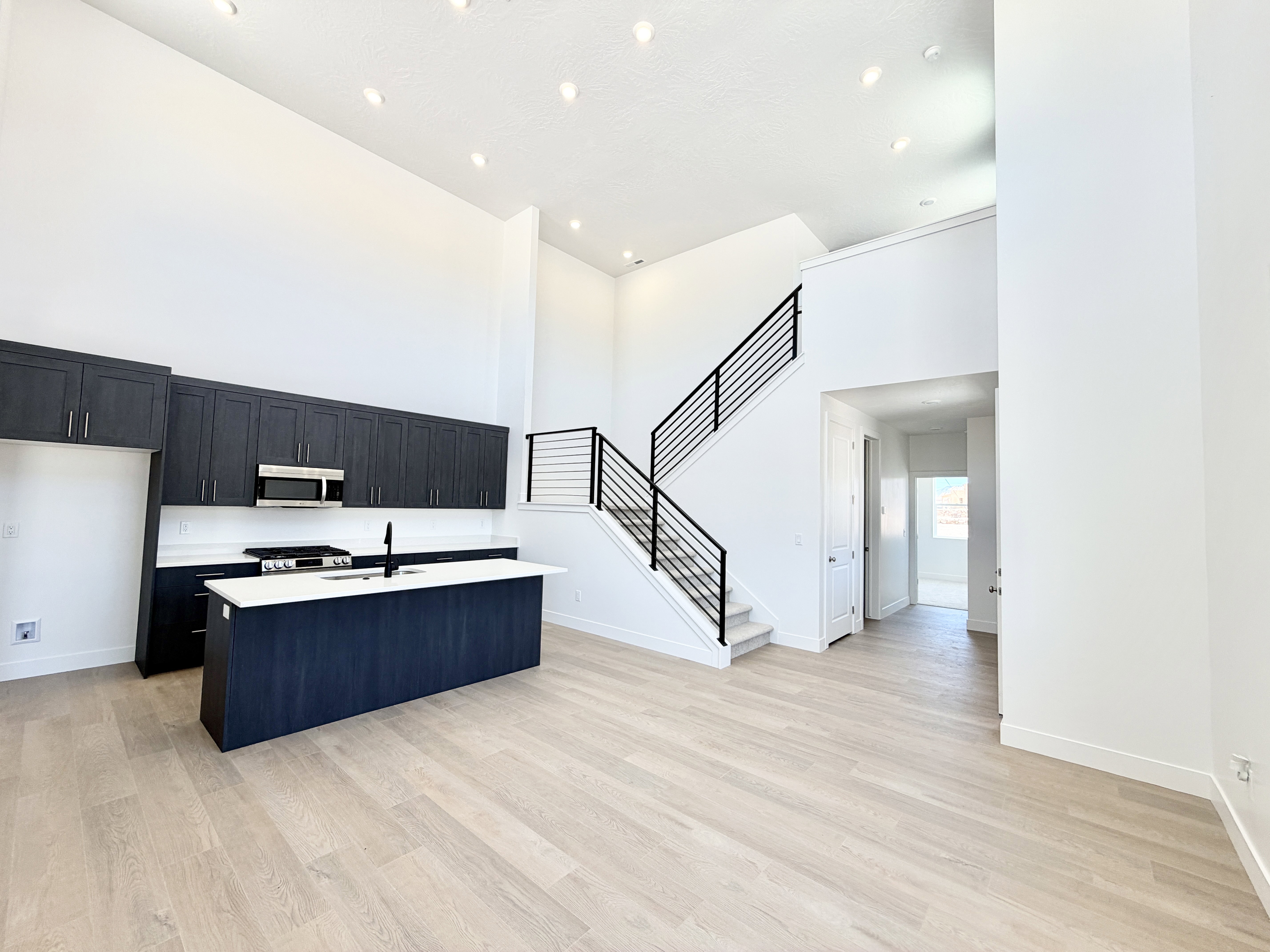 Open-concept living area with soaring ceilings and light wood-finish flooring