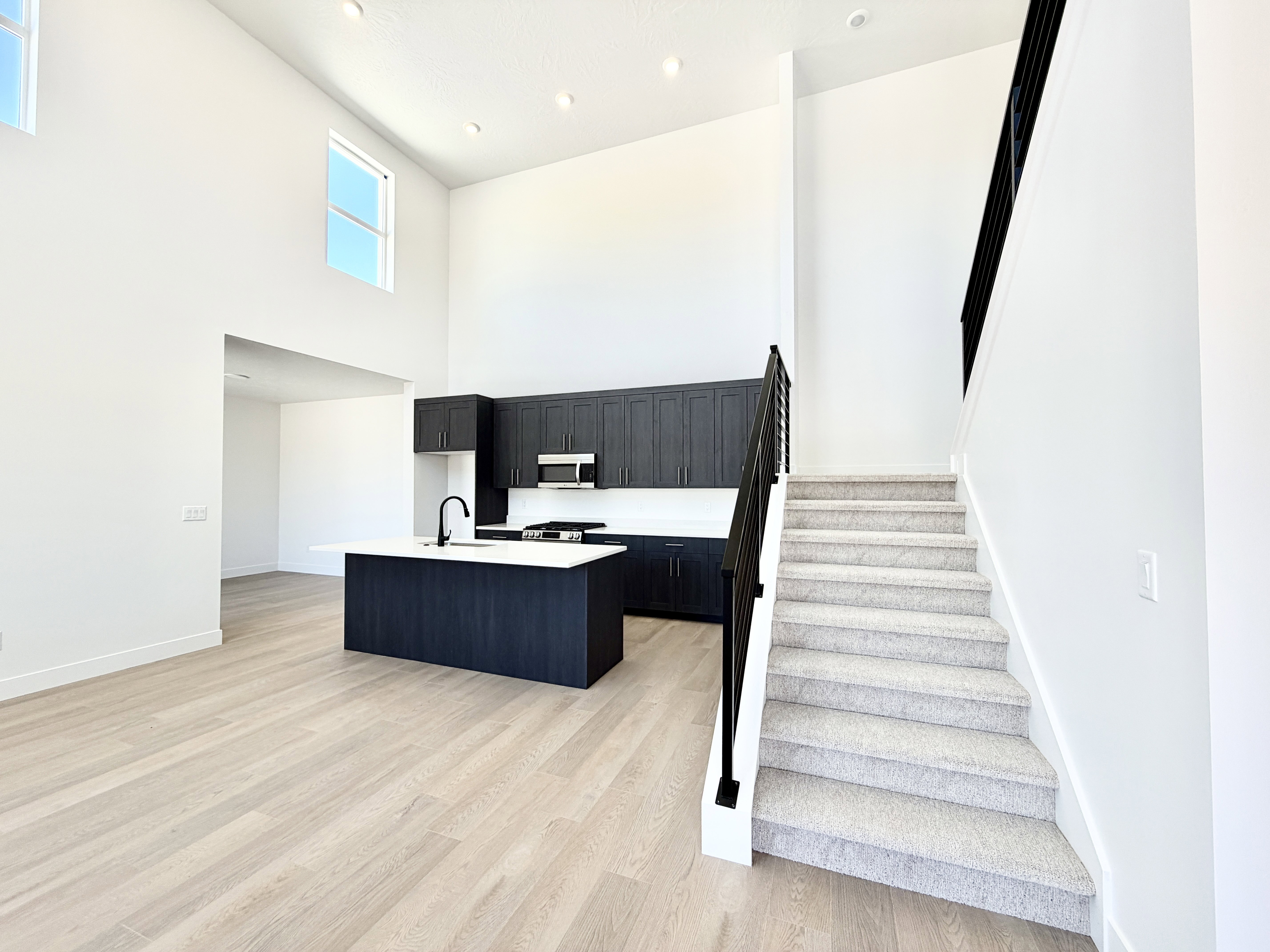 Open-concept living space with soaring ceilings and light wood-finish flooring