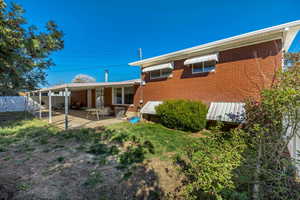 Rear view of house with a patio area and brick siding