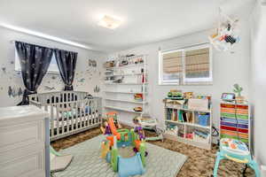 Bedroom featuring light carpet and a nursery area