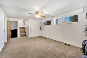 Unfurnished living room with carpet floors and ceiling fan
