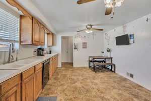 Kitchen featuring light countertops, dishwasher, a ceiling fan, and wood finish cabinets