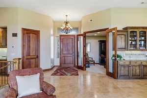 Entrance foyer with a chandelier and baseboards
