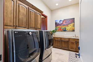 Laundry room featuring cabinet space, washing machine and dryer, and recessed lighting