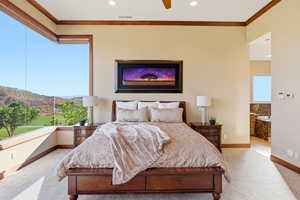 Bedroom featuring carpet, a mountain view, ornamental molding, a ceiling fan, and ensuite bath
