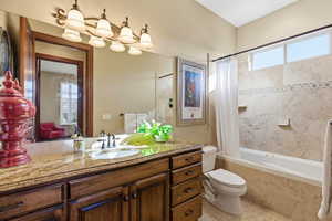 Bathroom featuring vanity, tiled shower / bath, and light tile patterned floors