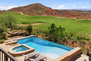 Relaxing pool / spa featuring a fenced backyard, a patio area, view of golf course, and a mountain view