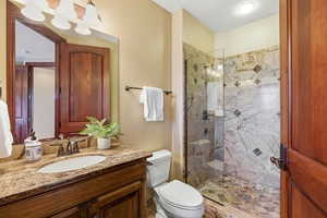 Bathroom featuring a marble finish shower and vanity