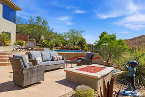 Fenced backyard featuring a patio and an outdoor living space with a fire pit